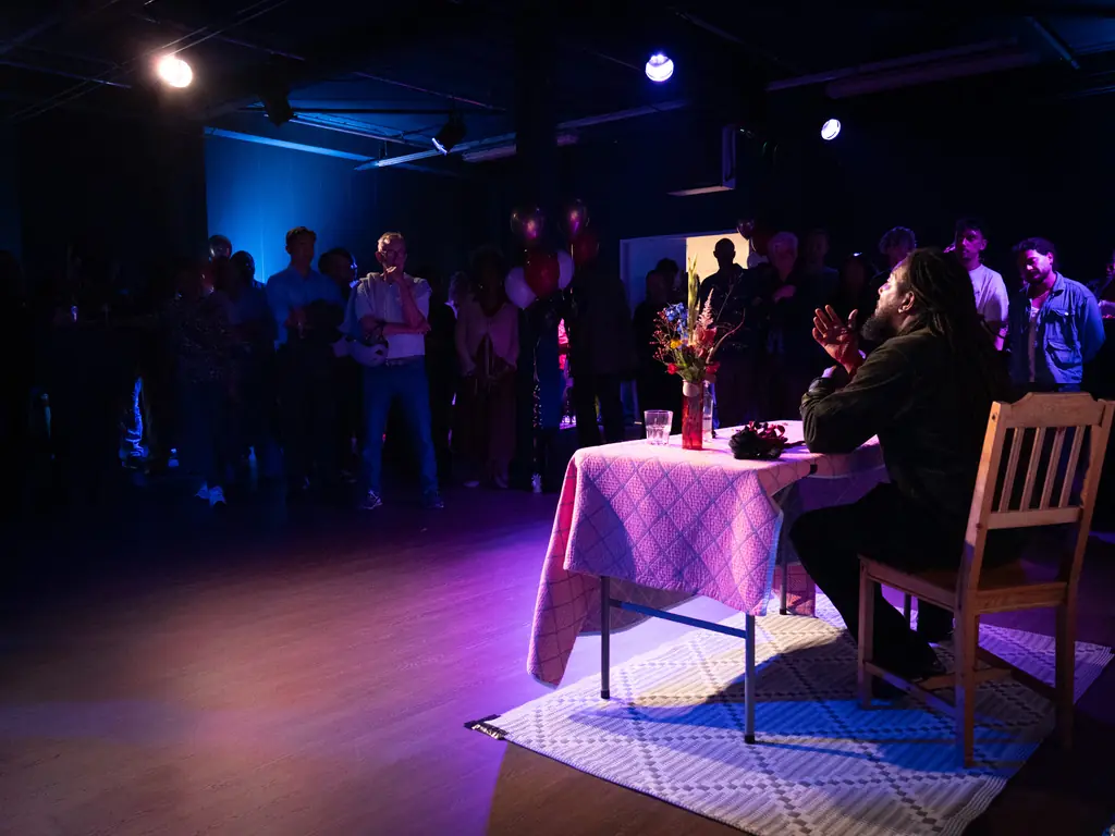 Spreker aan tafel voor een volle zaal tijdens de opening van Podium Oost